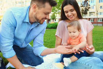 Happy family with adorable little baby outdoors