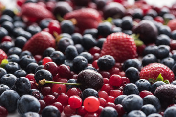 selective focus of red, fresh and ripe cranberries, strawberries, blueberries and wet cherries