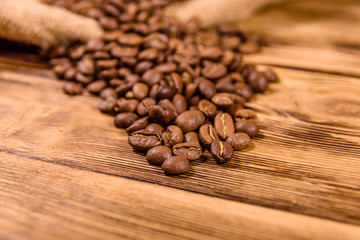 Sackcloth and scattered coffee beans on wooden table