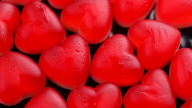 Heart shaped red jelly candy rotated background. St. Valentines, love concept. Slow motion. 4K UHD video footage. 3840X2160