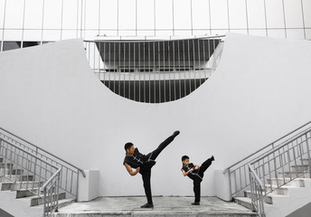 Father and son are engaged in Wushu in the city. The photo illustrates a healthy lifestyle and...