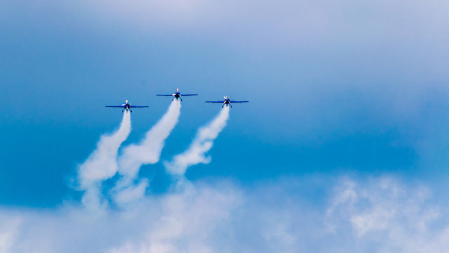 3 performance jets, flying in tandem, on a blue sky with white clouds