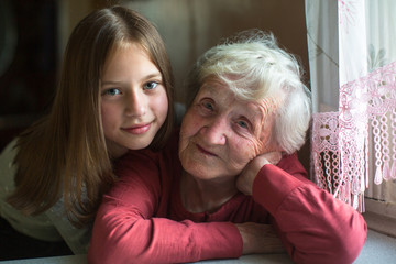 Portrait of an elderly woman with her young great-granddaughter.