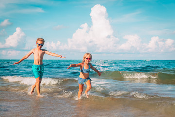 happy boy and girl run play at beach