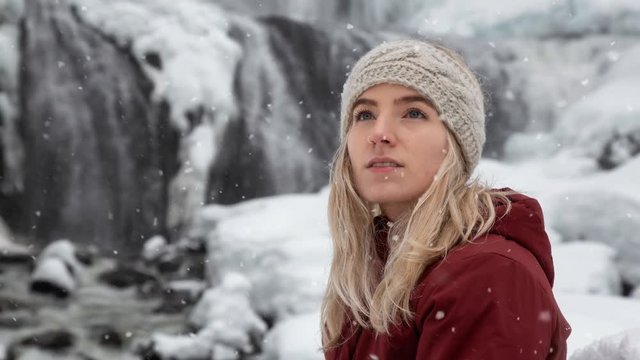 Blonde Caucasian Girl is enjoying the beautiful Canadian Winter Scenery during a snowy day. Taken in Alexander Falls, near Whistler and Squamish, North of Vancouver, BC, Canada. Still Image Animation