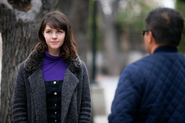 Woman walking outdoors in the city and looking snobby while running into an ex boyfriend or looking...