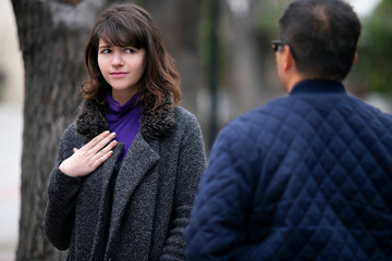 Woman walking outdoors in the city and looking snobby while running into an ex boyfriend or looking annoyed by an insulting stranger.  It also depicts social anxiety.