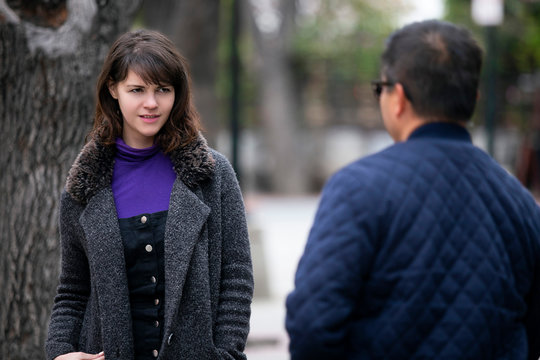 Woman walking outdoors in the city and looking snobby while running into an ex boyfriend or looking annoyed by an insulting stranger.  It also depicts social anxiety.