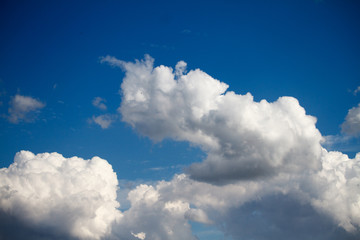 Landscape with blue sky and white cumulus clouds, background or concept