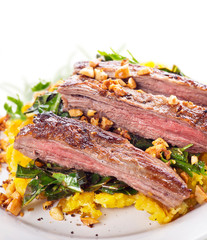 flank steak with mashed plantain , collard greens and ginger peanuts