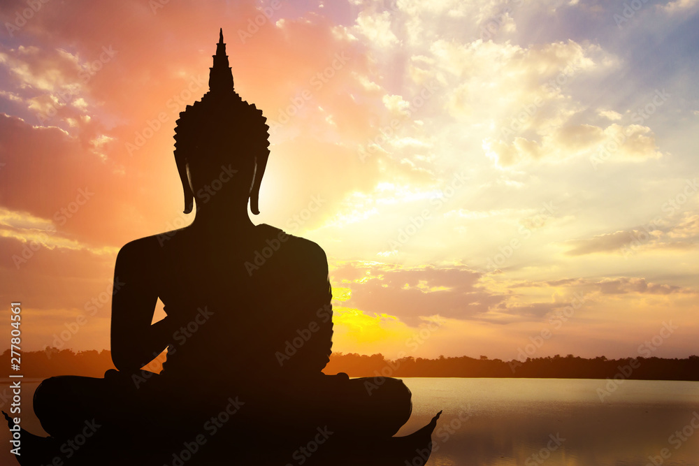 Wall mural magha asanha visakha puja day , silhouette buddha on golden sunset background.