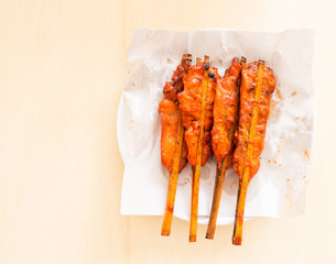 Grilled chicken on bamboo skewers on wooden backgroud.top view