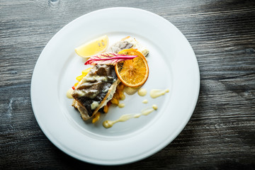 top view of roasted sea fish on pickled pepper garnish