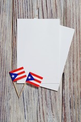 Fototapeta na wymiar Puerto Rico independence day. day of constitution 25 July. the concept of veterans Day or memorial . mini flags with sheets of white paper on white wooden background.mockup, copy space. vertical