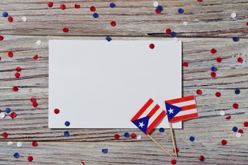 Puerto Rico independence day. day of constitution 25 July. the concept of veterans Day or memorial. mini flags and confetti with sheets of white paper on a white wooden background. mockup, copy space 