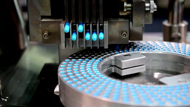 Blue capsule medicine pill production line, Industrial pharmaceutical concept.
