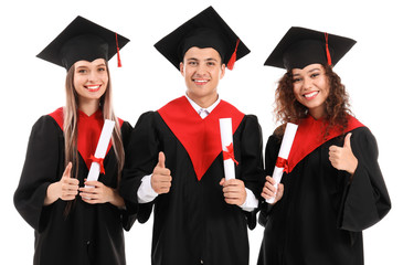 Young students in bachelor robes showing thumb-up on white background