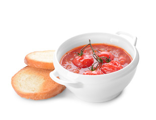 Pot of tasty tomato cream soup and bread on white background