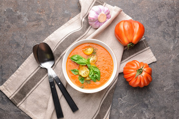 Bowl of tasty tomato cream soup on grey background