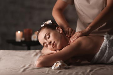 Obraz na płótnie Canvas Young woman having massage in spa salon
