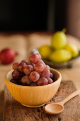 Healthy Organic grape in wood plate on wooden table.