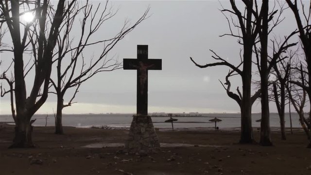 Christian Cross with Crucified Jesus Christ Statue in a Road to the Submerged City of Epecuen, in Argentina.