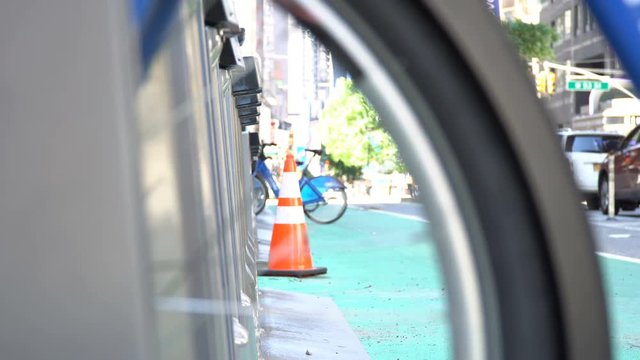 Bicycle rental station shot through a bike wheel, changing focus slowly, great intro video on a Rent a bike in New York topic