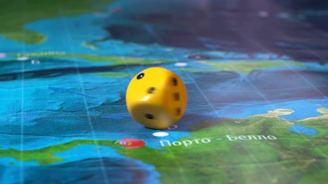 Hand throws the dice on the background of colorful blurred fantasy Board games, gaming moments in dynamics