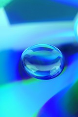 Drop  background.Water drop on a deep blue iridescent background with gradation and highlights. Abstract blob texture background.Phone wallpaper