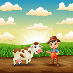 Young farmer with his cow in the field