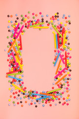 Colorful sprinkles  and birthday candles on pink background
