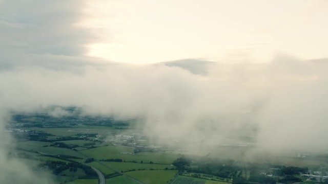 An aerial evening shot with the camera inside the rolling clouds, above a beautiful countryside  | Edinburgh | Shot in 4k at 30 fps