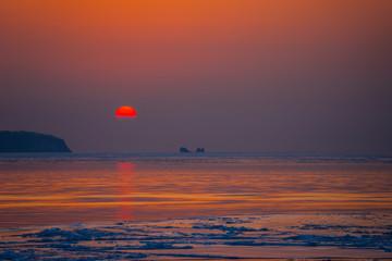 Seascape ice beach and the red sunset.