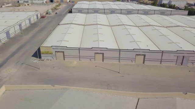 Storage facility warehouses side by side in the desert with designated parking spaces and garage gates (4K)