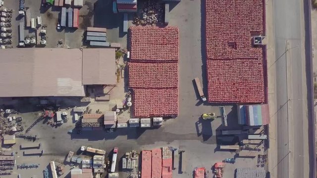 A container cargo carrier loads a truck with its blue cargo in a container yard (4K)