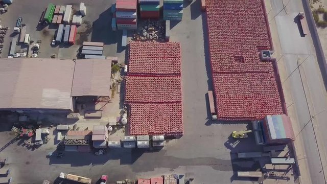 A cargo loader forklift loads a container on the back of a truck in a large container yard (4K)