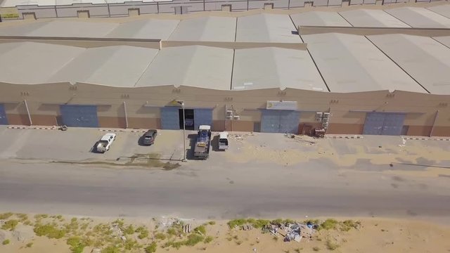 Warehouses side by side in the desert with garage gate doors and a small door next to it (4K)