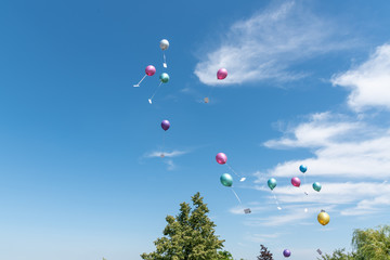balloons with greeting cards in the sky