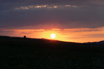cross on rock altar with sunset