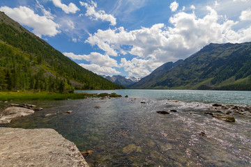 Multinsky averadge lake in Altai mountains. Picturesque landscape with transparent water and huge stone. Summer time.