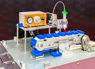 Close up High precision and technology of nozzle device and needle of automatic glue dispenser machine (glue injection) working on belt conveyor at factory