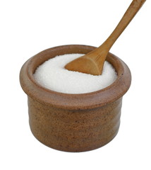 Heap of granulated sugar in a clay bowl with spoon isolated on white background.