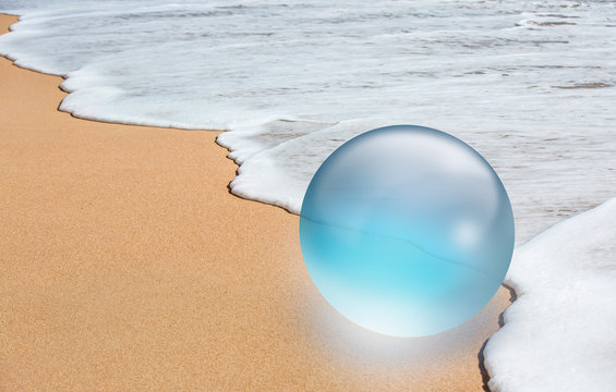 Crystal ball with shell in the sand dune and sea foam