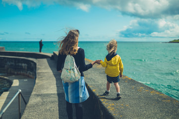 Mother and toddler walking by the sea