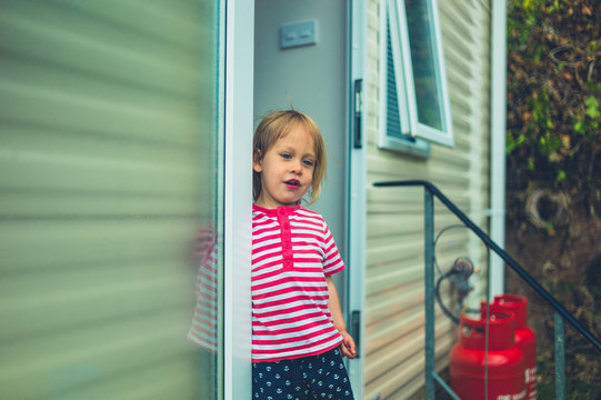Little toddler standing in the door of trailer