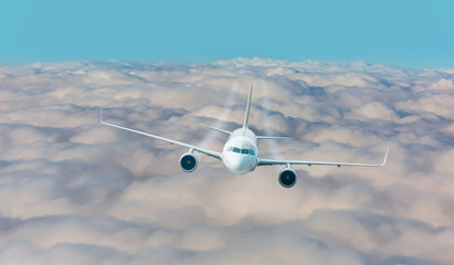 Passenger airplane jet flying over low clouds and city