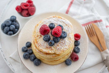 home made sweet vanilla pancakes with berries on a table
