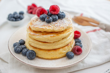 home made sweet vanilla pancakes with berries on a table