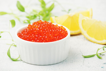 A small ceramic bowl with red caviar	