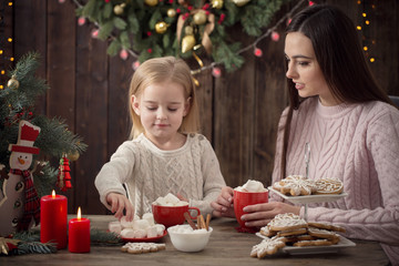 Mother and little girl with christmas cookies  at home